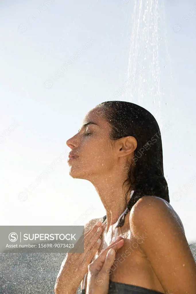 Mid_adult woman showering outdoors