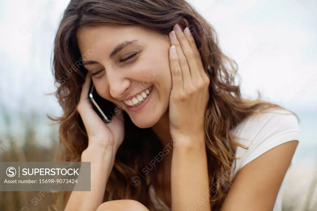 Happy young woman talking on cell phone, portrait