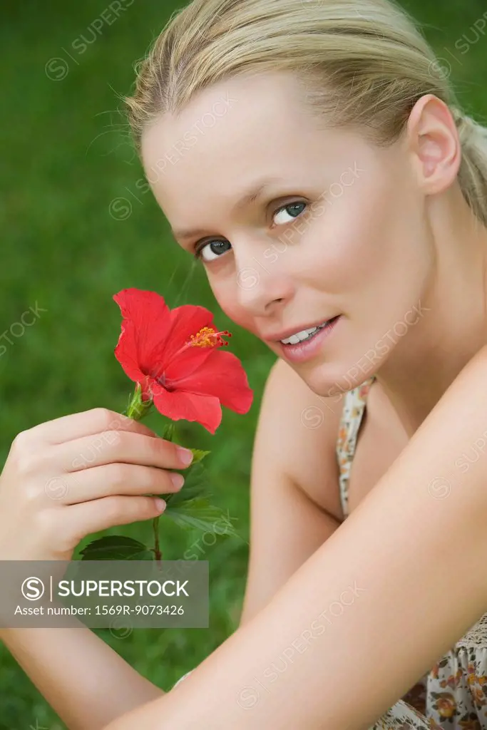 Young woman with hibiscus flower, portrait