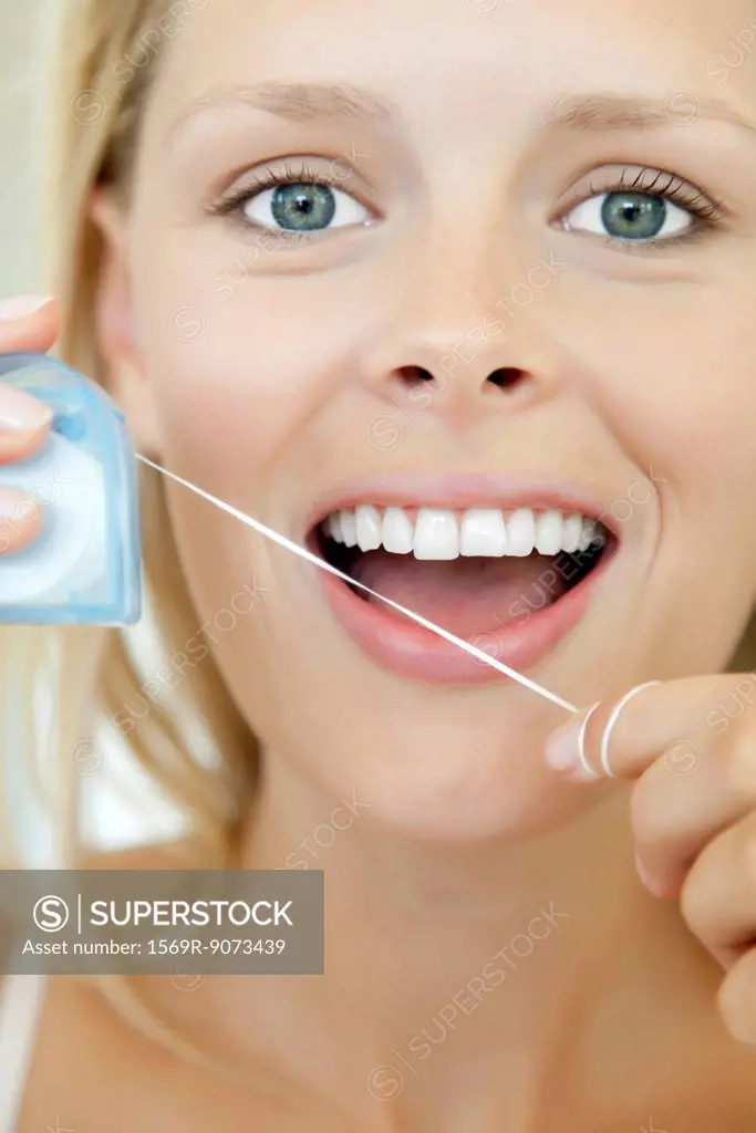 Young woman using dental floss