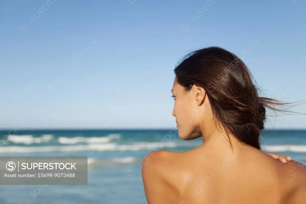Woman looking at ocean, rear view