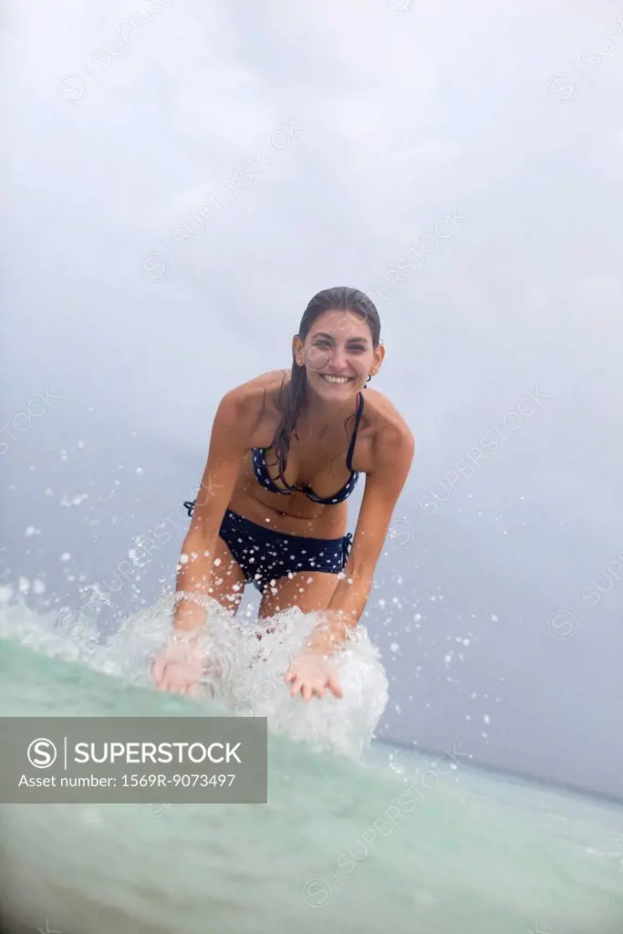 Young woman splashing water