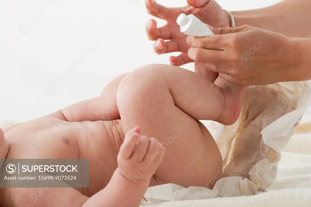 Infant having diaper changed, cropped