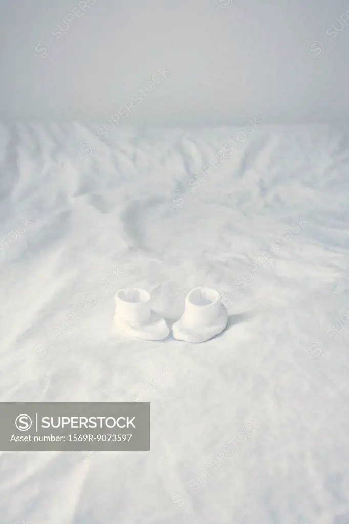 Baby booties on bed