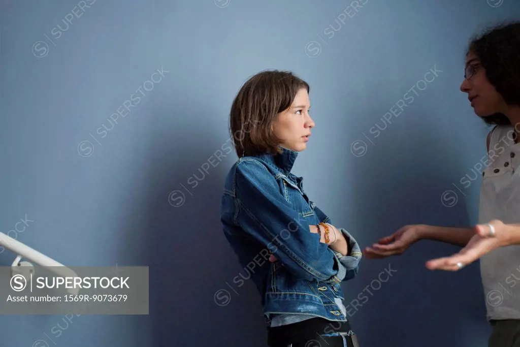 Young woman apologizing to upset friend