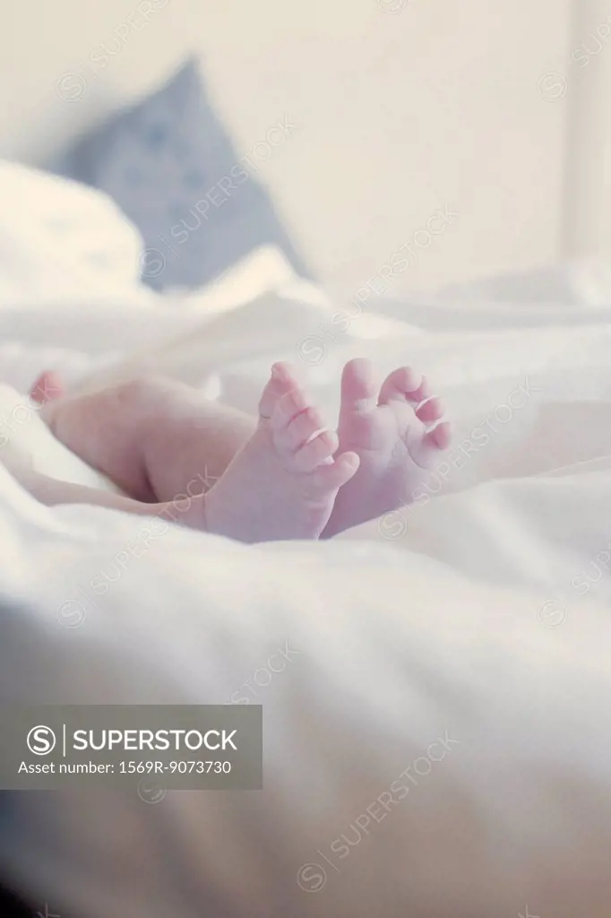 Baby´s bare feet on bed