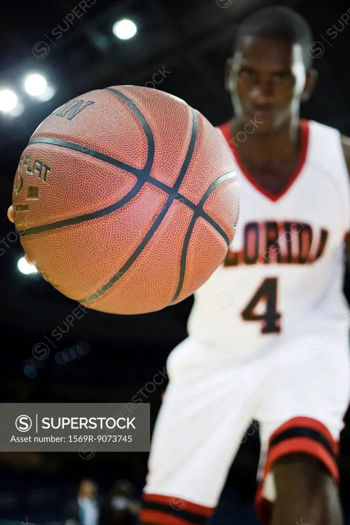 Basketball player dribbling basketball, low angle view