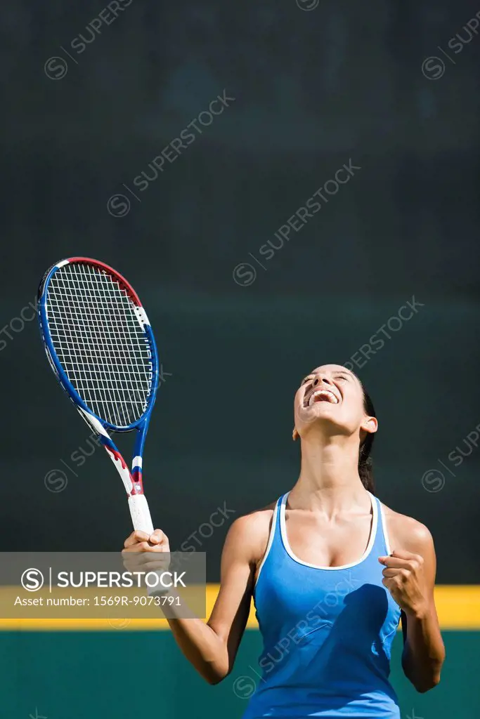 Young female tennis player cheering, portrait