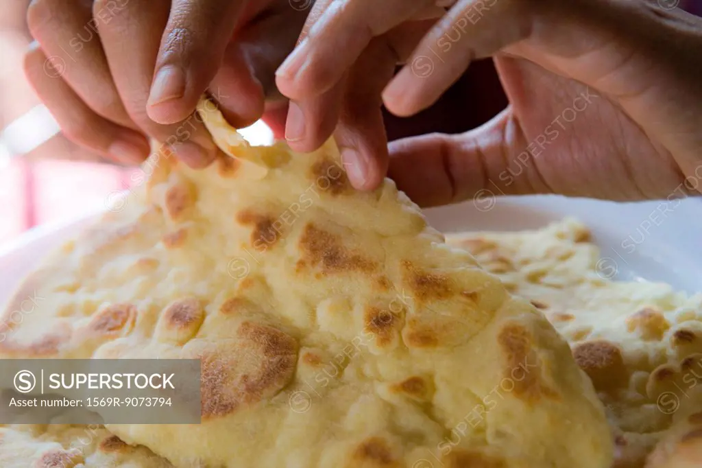 Person tearing naan