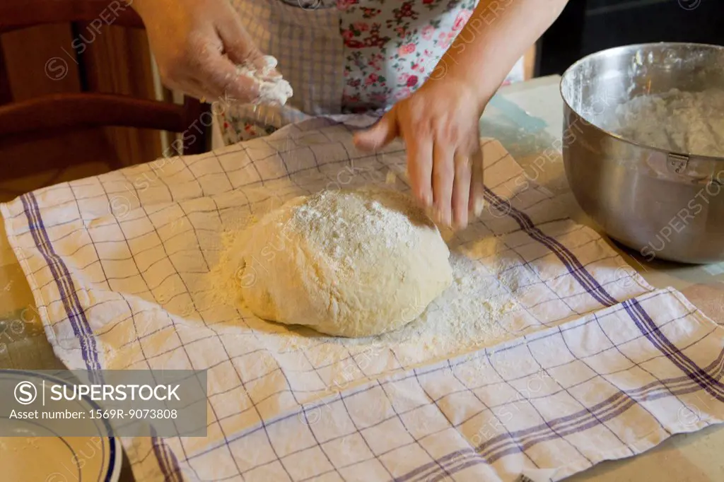 Woman flouring fresh dough, cropped