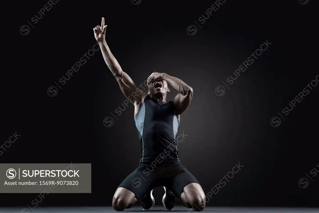 Male athlete shouting with finger pointing up