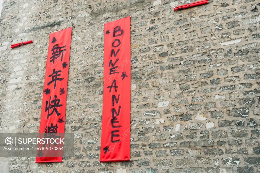 Couplets in with Chinese and Western scripts hanging on brick wall