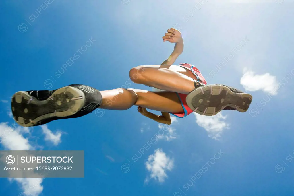 Female athlete jumping in air, directly below
