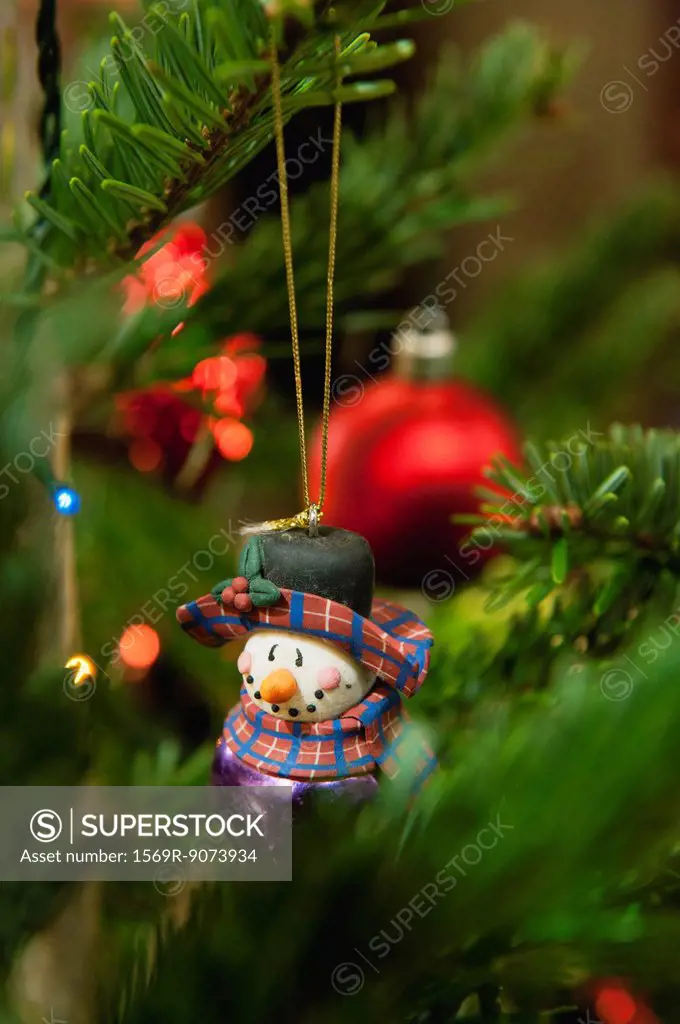 Snowman ornament hanging on Christmas tree