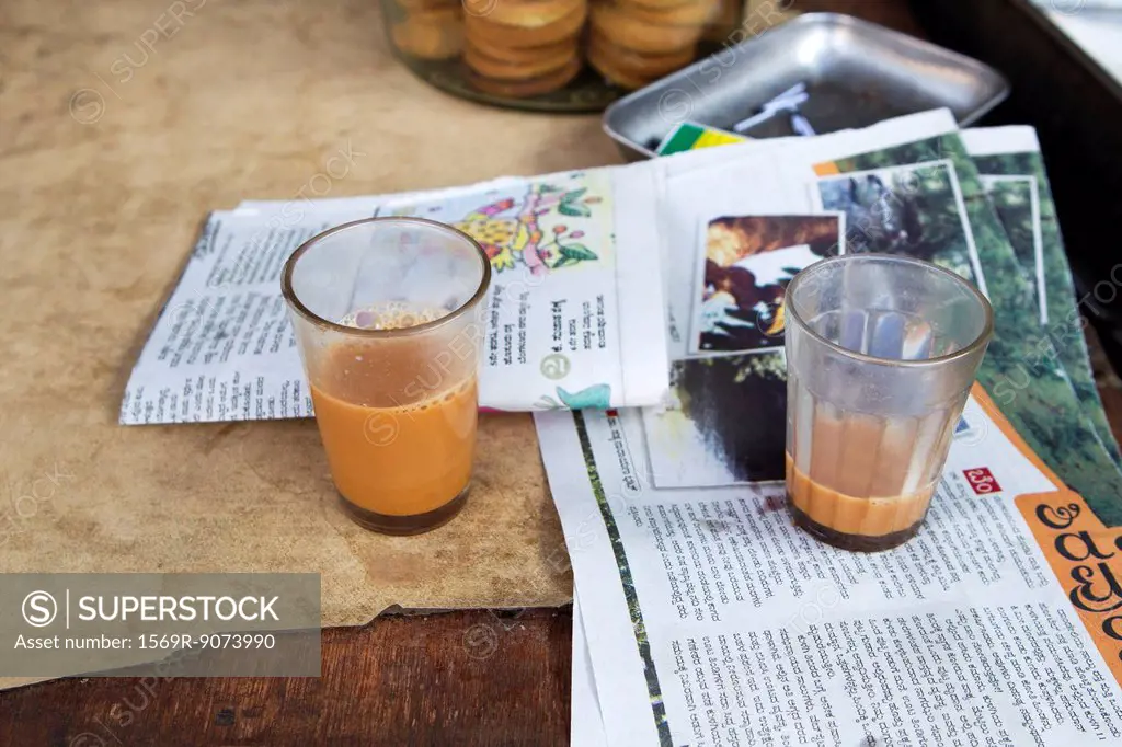 Glasses of chai tea and newspaper on table