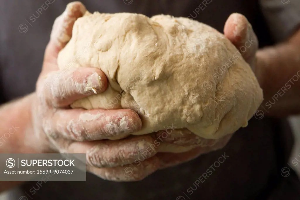 Man´s hands holding fresh bread dough