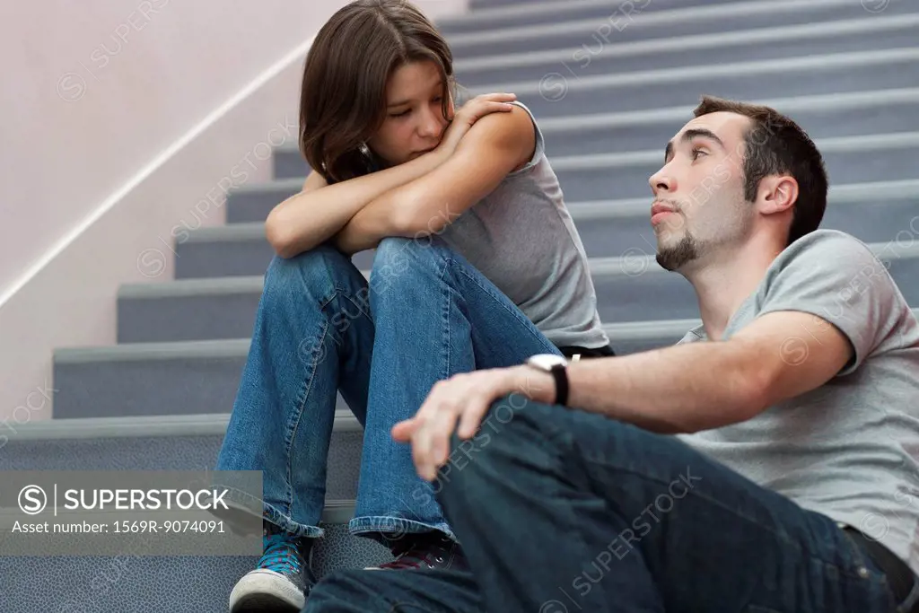 Young couple talking together on stairs