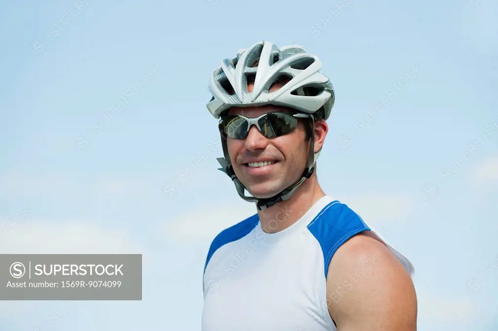 Man wearing cycling helmet and sunglasses, portrait