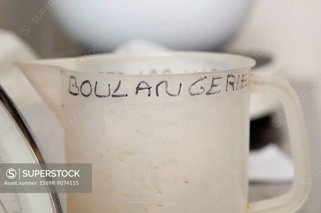 Plastic measuring cup with ´boulangerie´ hand written on it
