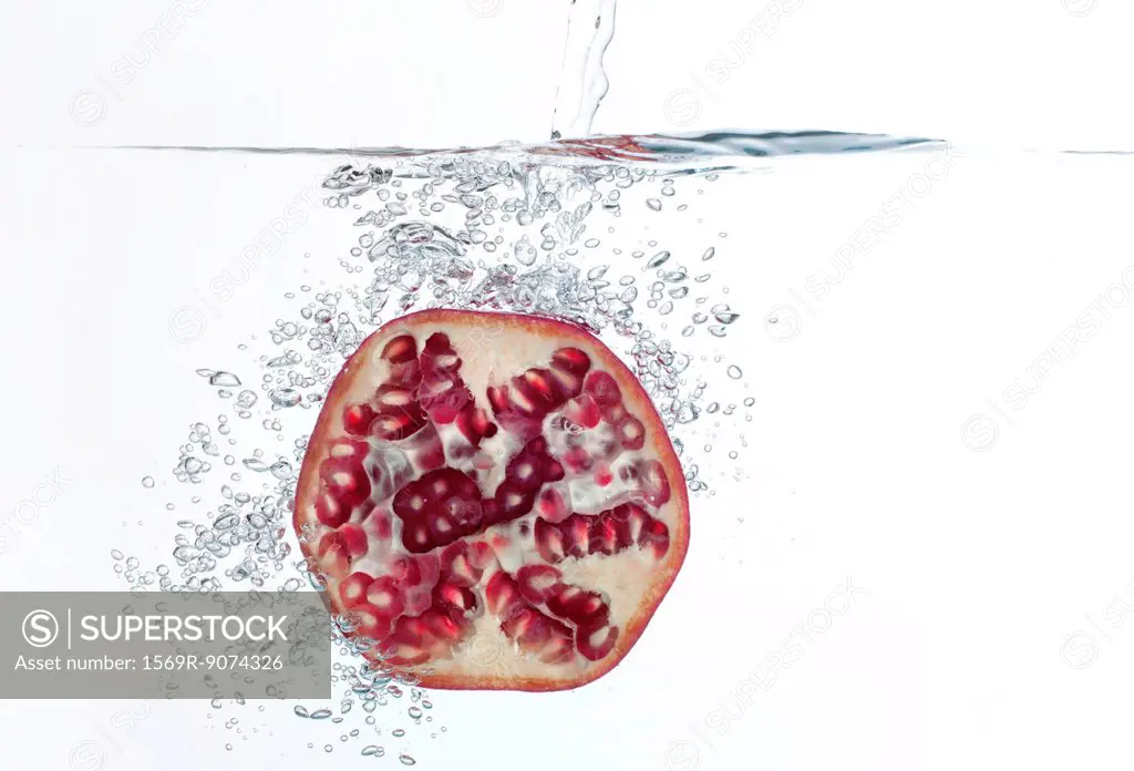Pomegranate half submerged in water