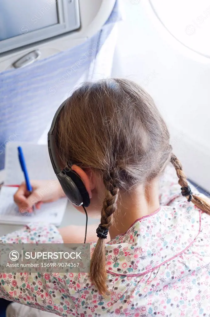 Girl writing on airplane