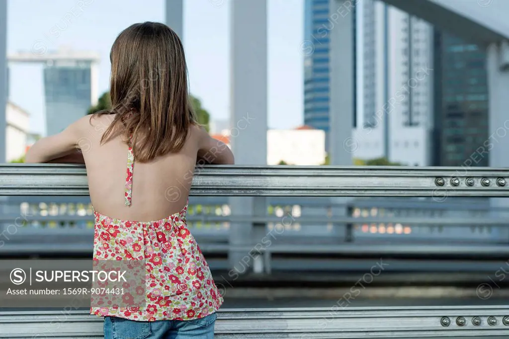 Girl looking at city skyline, rear view