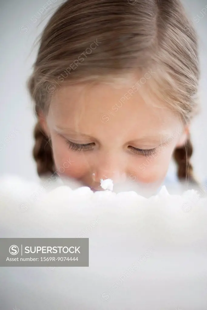 Girl with cake frosting on her nose