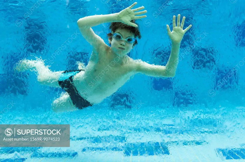 Boy swimming underwater in swimming pool