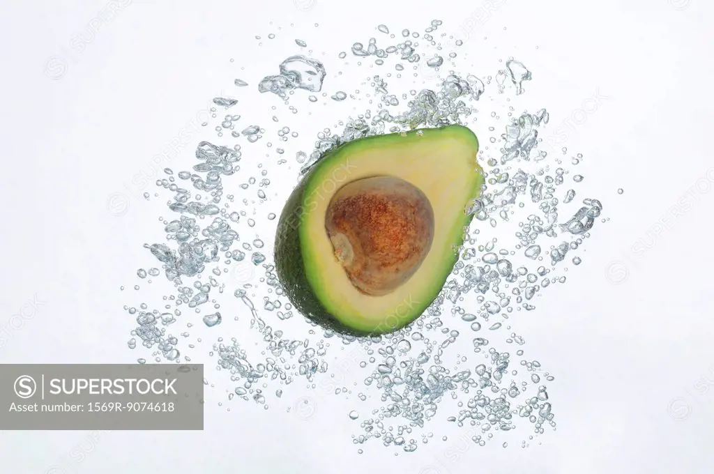 Avocado half submerged in sparkling water