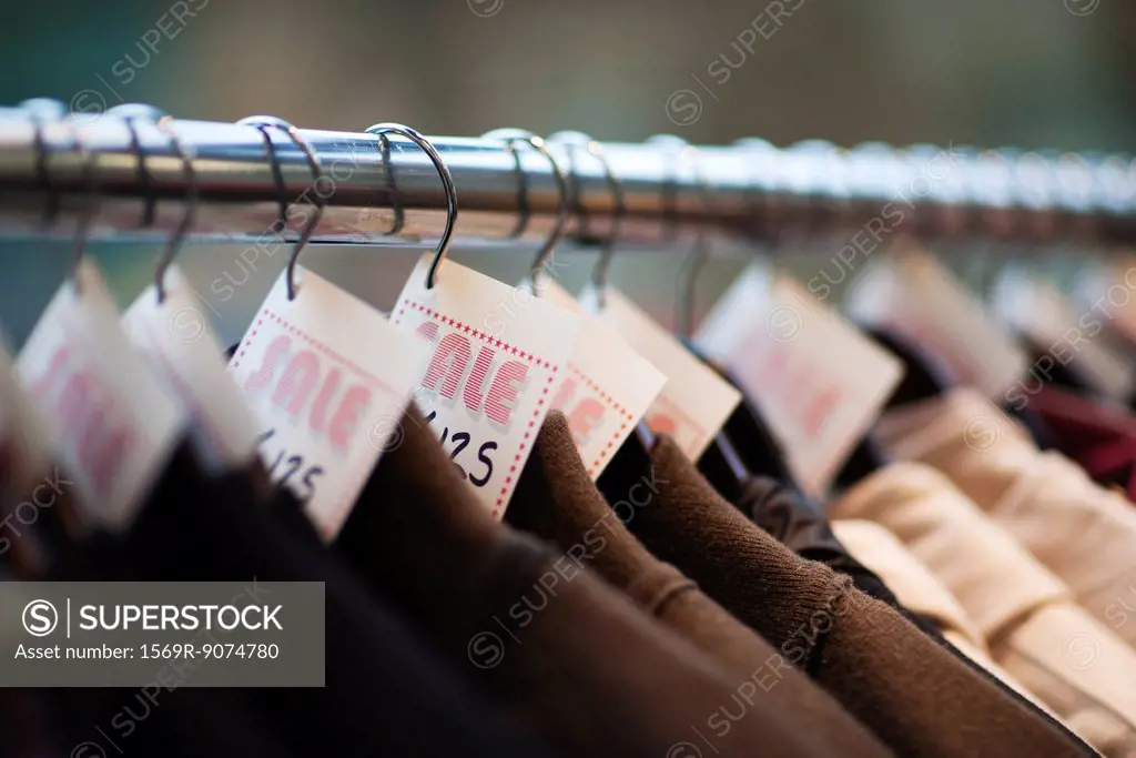 Sale tags on clothing in store, cropped