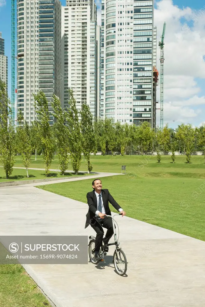 Businessman riding bicycle in park