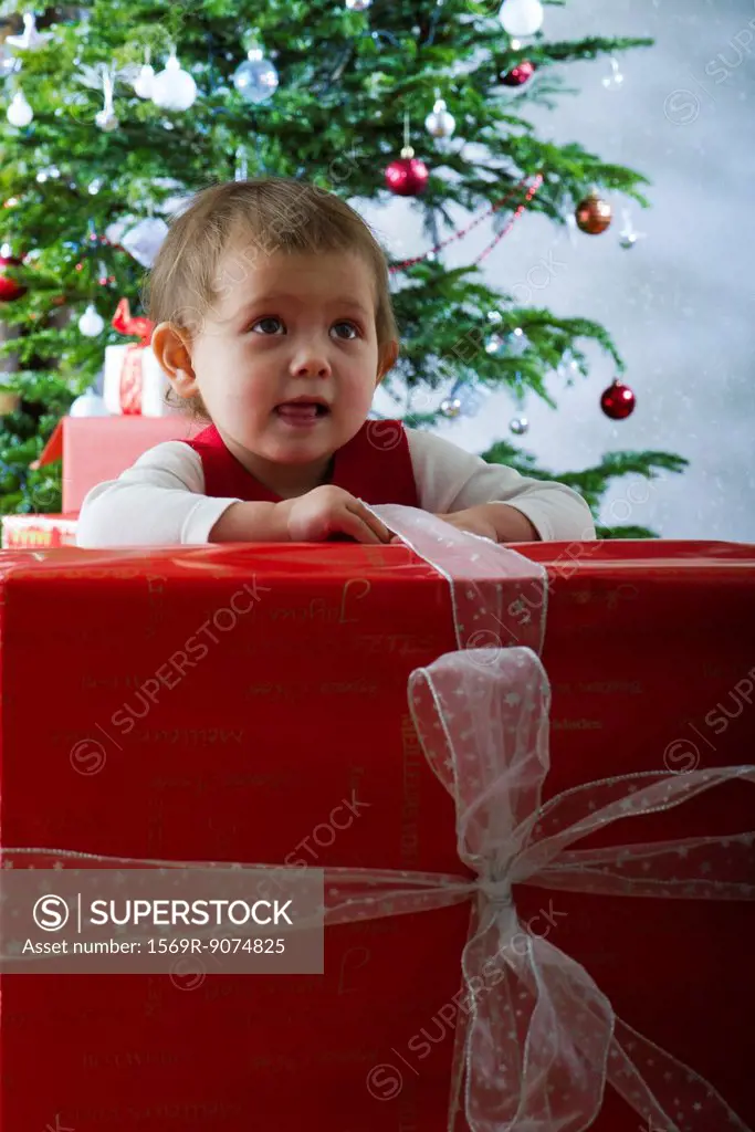 Baby girl opening large Christmas present