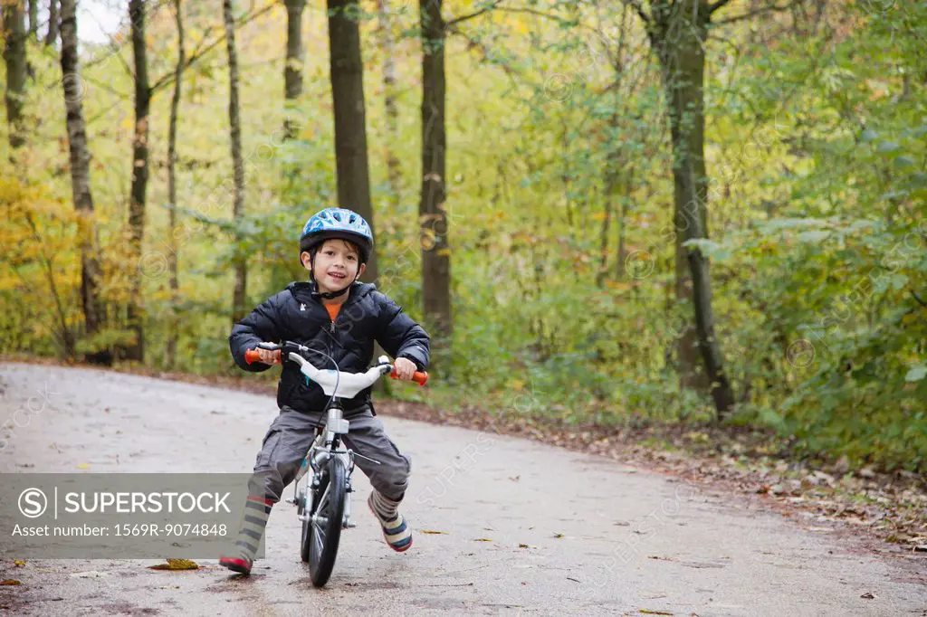 Boy riding bike, smiling at camera