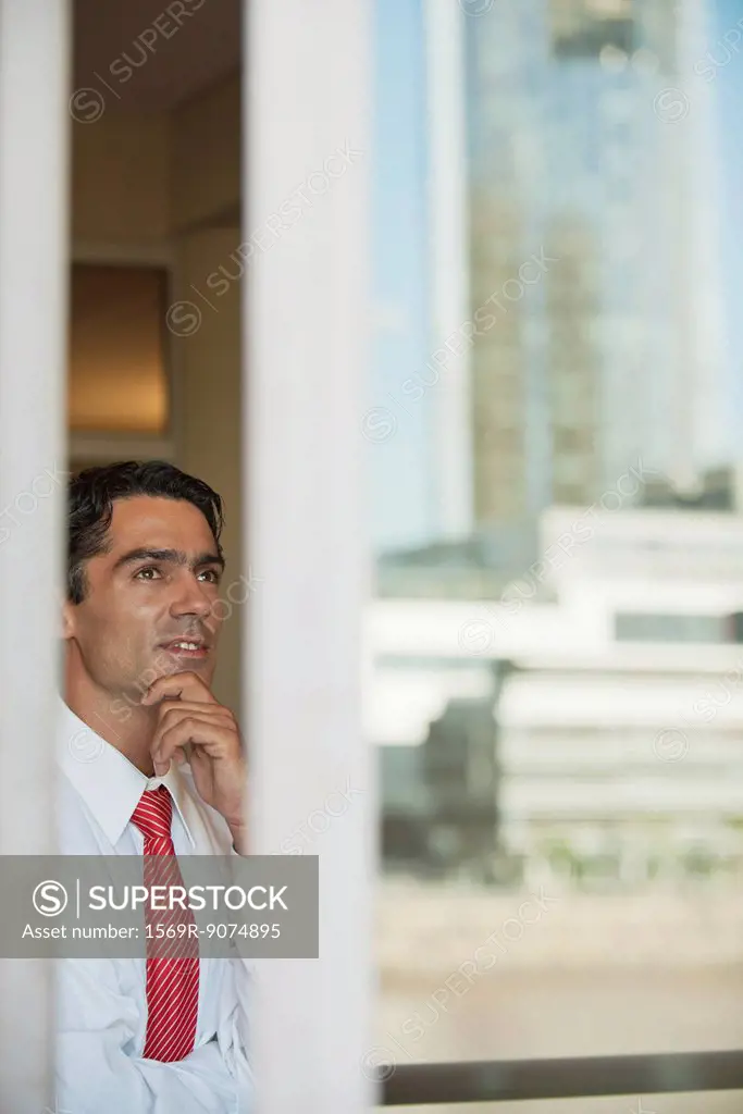 Businessman in office, seen from outside of window