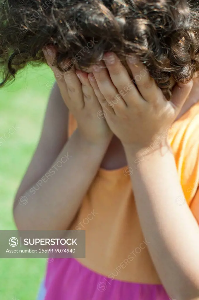 Girl covering face with hands