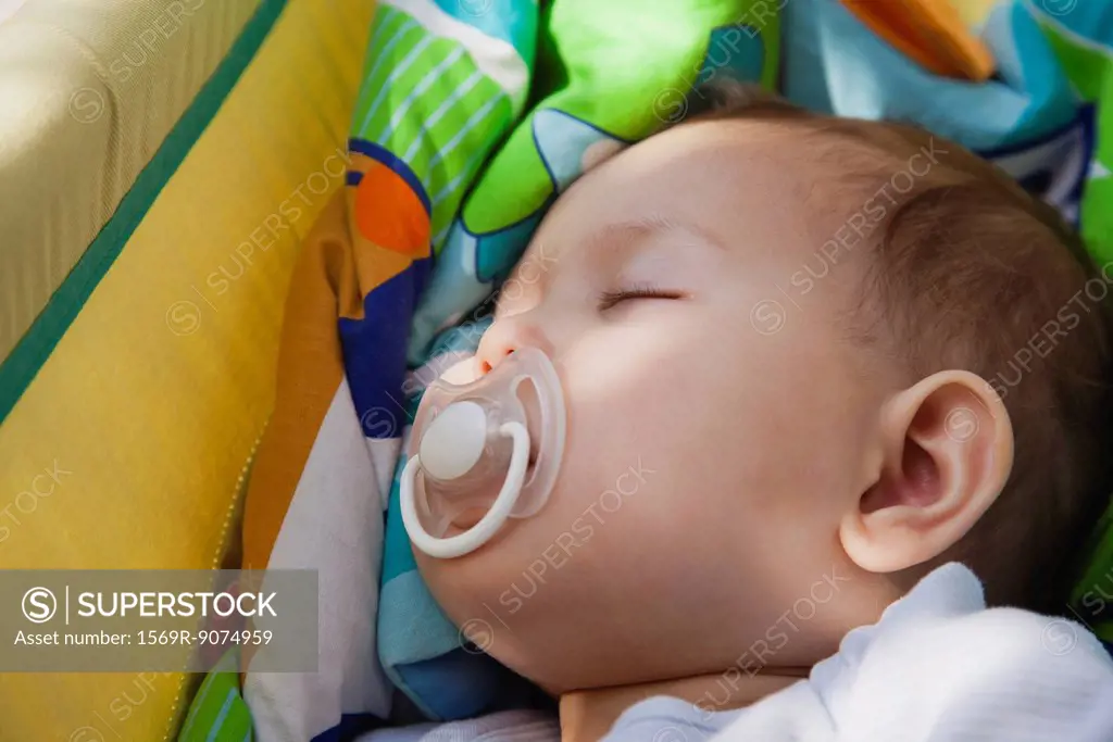 Baby girl napping with pacifier in her mouth