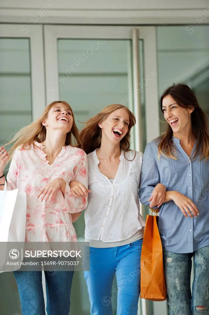 Young women walking together, carrying shopping bags