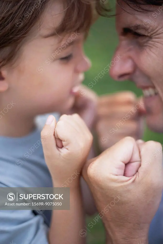 Father and son goofing off with fists clenched