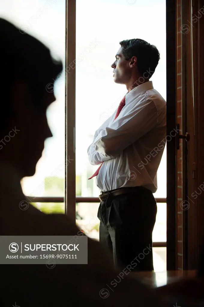Silhouette of businessman standing by window