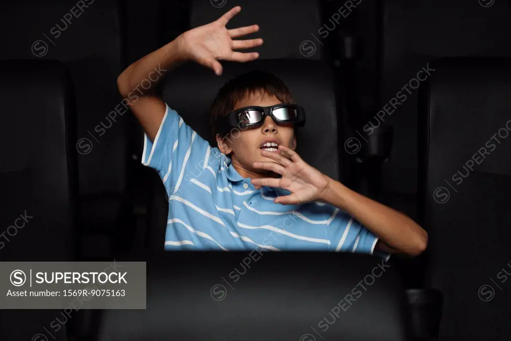 Boy watching 3_D horror movie in theater