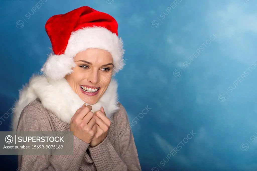 Woman wearing Santa hat, hands clasped in anticipation