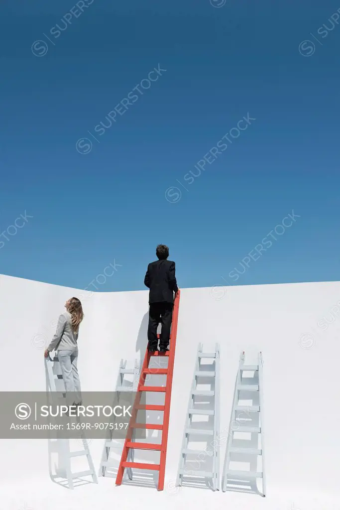 Businessman and businesswoman climbing ladders