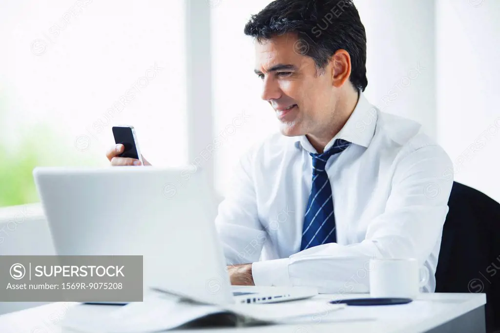 Businessman using cell phone at work