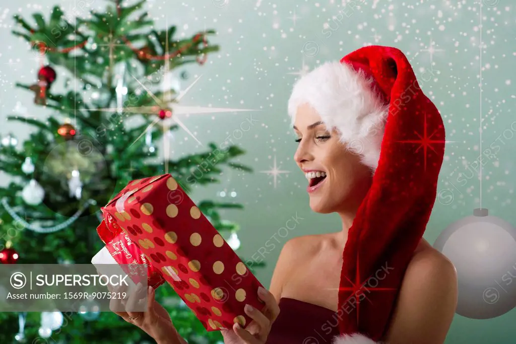 Woman wearing Santa hat, looking at Christmas gifts