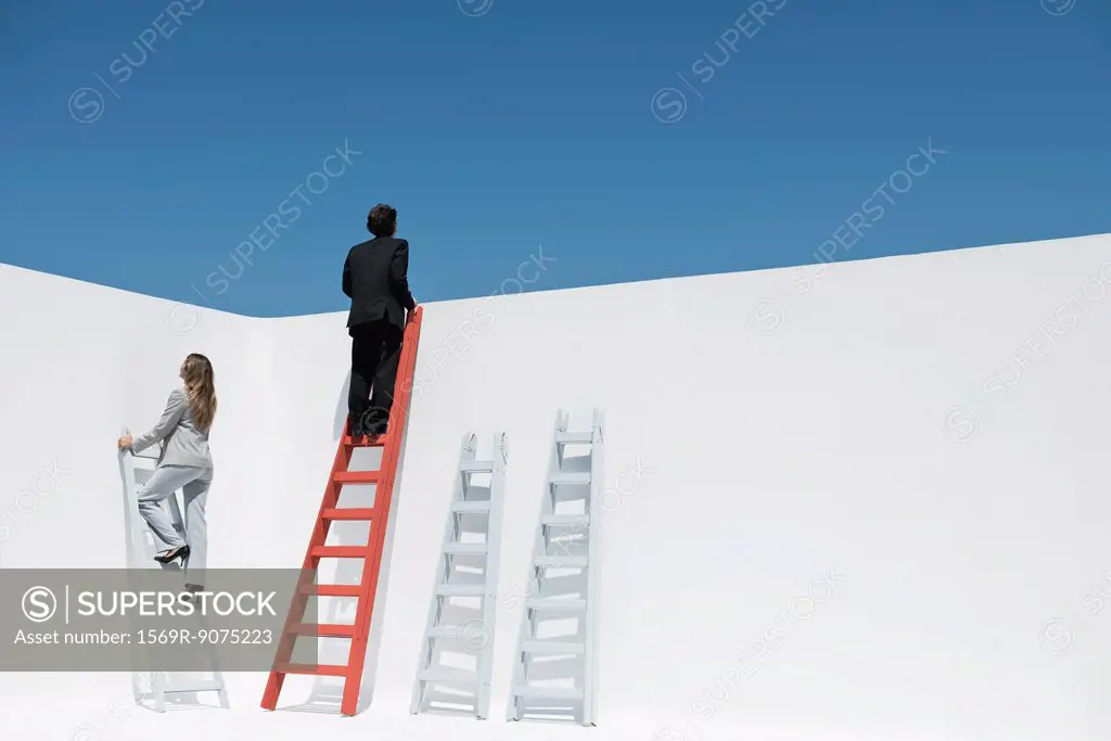 Businessman and businesswoman climbing ladders