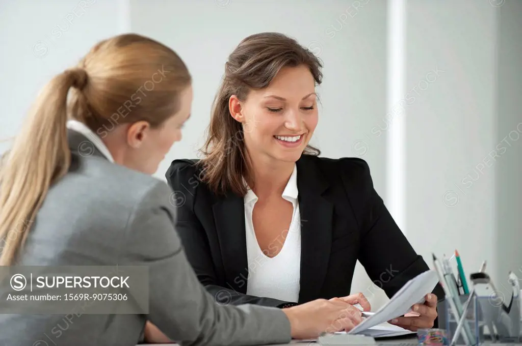 Businesswoman reviewing document with client