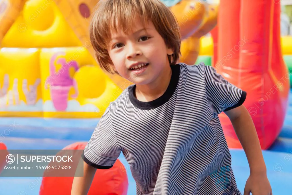 Boy playing in bouncy castle, portrait