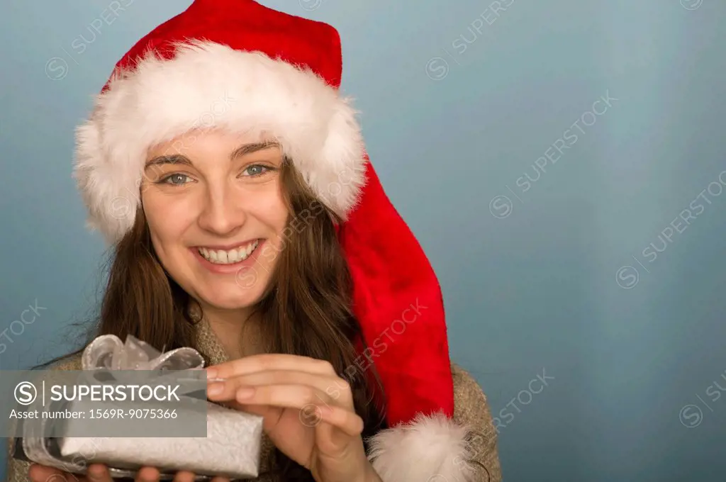 Young woman holding Christmas present, portrait