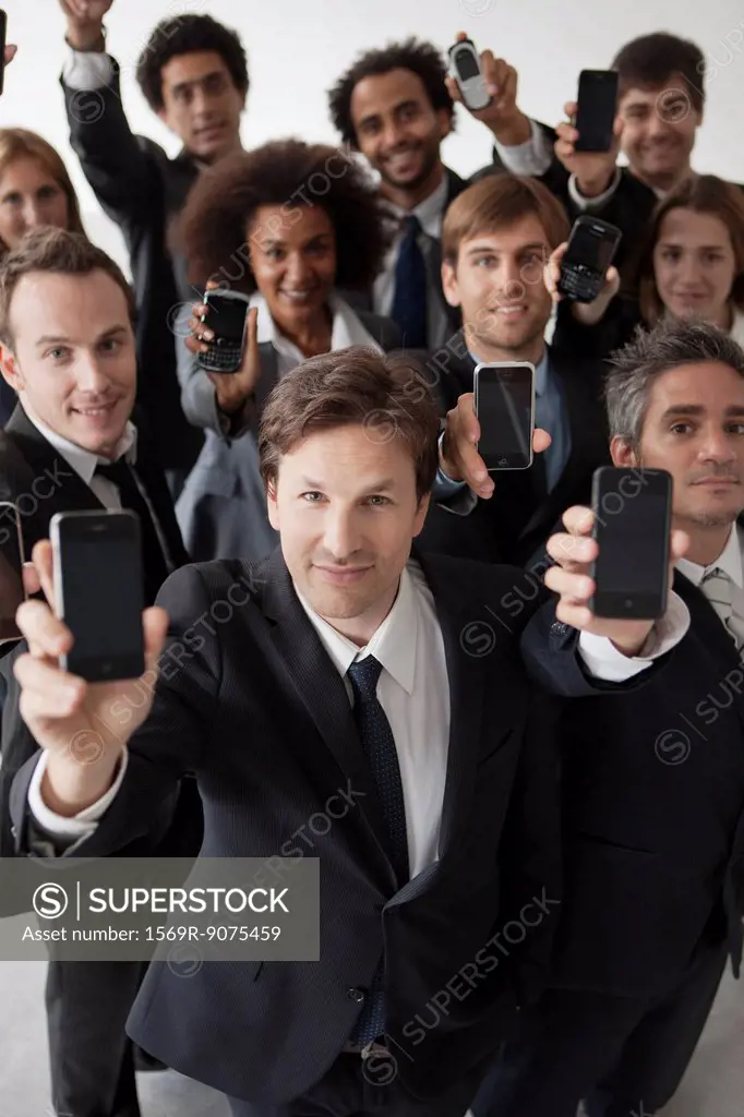 Business professionals holding aloft their cell phones