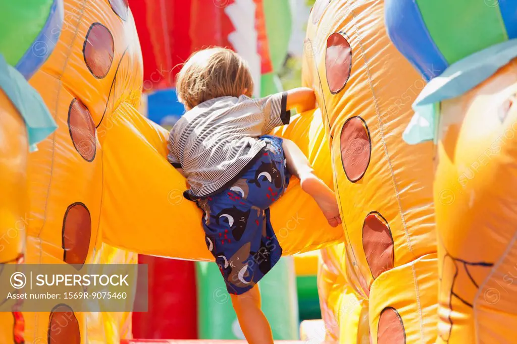 Boy playing in bouncy castle, rear view